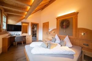 a bedroom with a large bed with white pillows at Panorama Hotel Himmelreich in Kastelbell-Tschars