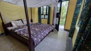 a bedroom with a bed with a canopy at Kilimanjaro Village Hotel in Mwika West