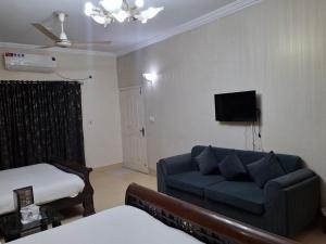 a living room with a couch and a bed at ButtLodges - 1 in Islamabad