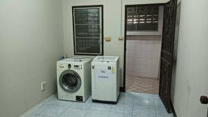 a washing machine and a washer in a bathroom at เจแปน บ้านพักรายวัน in Pak Chong
