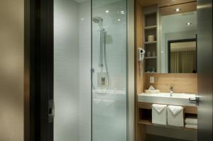 y baño con ducha y lavamanos. en Motel Idéal Ste-Rose, en Laval