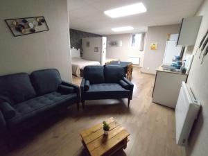 a living room with two couches and a room with a bed at Le domaine de Fillette in Einvaux