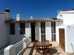 a patio with a table and chairs on a house at Casa Rural El Aljibe in Benamahoma