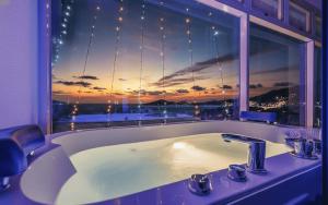 a bathroom with a bath tub and a window with a view at Yeosu View21 Pension in Yeosu