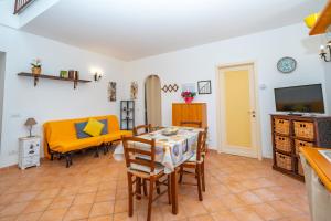 a living room with a table and a yellow couch at La Casa Dei Venti in Amalfi