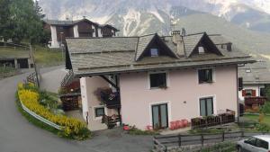 a large white house with a mountain in the background at Fiocco di neve in Valdisotto