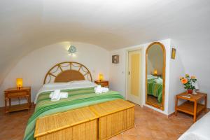 a bedroom with a large bed and a mirror at La Casa Dei Venti in Amalfi