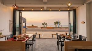 a restaurant with tables and chairs with a view of the ocean at Yangyang Verit Pension in Yangyang