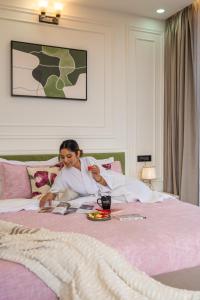 a woman laying on a bed talking on a phone at Perfectstayz Luxe kapilaz - Jacuzzi rooms in Bhowāli +150 photos