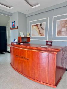 a wooden reception desk in a room with paintings at Mbogo Safari Hotel in Karatu