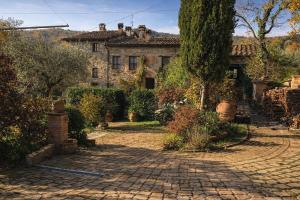 an old stone house with a cobblestone driveway at B&B Il Casale Del Ginepro in Migliano