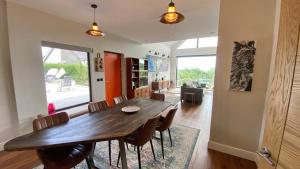 a dining room with a wooden table and chairs at Woodcroft in Pwllheli