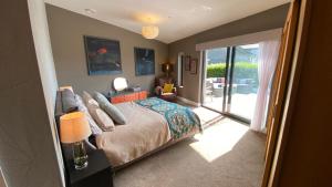 a bedroom with a bed and a sliding glass door at Woodcroft in Pwllheli