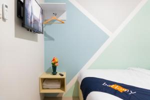 a bedroom with a bed and a tv at Behomy Suhat Malang in Karangjepun