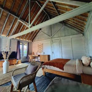a bedroom with a bed and a chair in a room at Rumah Kayu Sari in Mengwi
