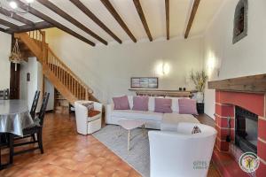 a living room with a couch and a fireplace at Le bois du chat in Plouha