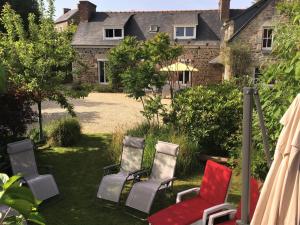four chairs sitting in the yard of a house at Le bois du chat in Plouha