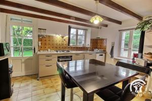 a kitchen with a table and a dining room at Le bois du chat in Plouha