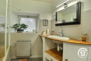 a bathroom with a sink and a mirror at Le bois du chat in Plouha +35 photos