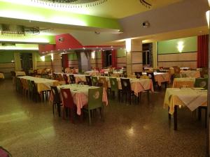 ein Esszimmer mit Tischen und Stühlen sowie einem gelben Tischtuch in der Unterkunft Hotel Royal Cattafi in San Filippo del Mela