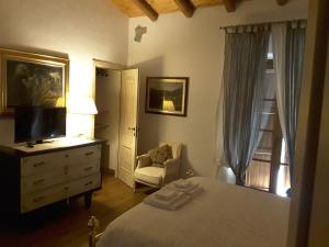 a bedroom with a bed and a dresser with a television at Il Giardino Di Rosmarino in Pontremoli