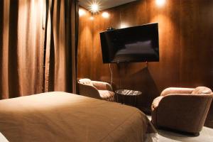 a hotel room with a bed and a flat screen tv at Hotel Avant in Cheonan