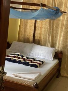 a bed with a wooden headboard with some food on it at Abdel & sons homes in Dodoma