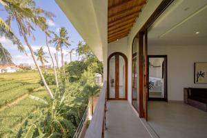 an external view of a house with a balcony with palm trees at Didi Apartment Seseh in Munggu