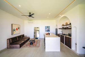 a kitchen and living room with a couch and a table at Didi Apartment Seseh in Munggu