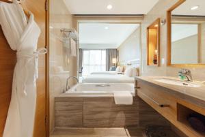 a bathroom with a tub and a sink and a mirror at Four Points by Sheraton Taicang in Taicang +19 photos