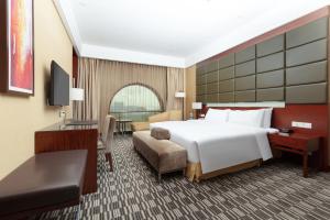 a hotel room with a large bed and a desk at Four Points by Sheraton Taicang in Taicang