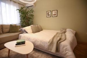 a living room with a white bed and a table at M&S Central Residence in Bitola