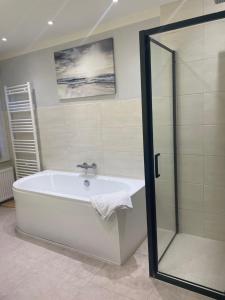 a white bath tub in a bathroom with a shower at Hotel Pommerscher Hof in Zinnowitz +51 photos