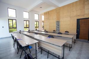 a classroom with wooden tables and chairs in a room at Lorateng' Resort - Rusinga in Mbita +147 photos