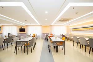 a restaurant with tables and chairs in a room at Ibis Shanghai Xujiahui in Shanghai