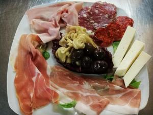 ein Teller mit Fleisch und Käse drauf in der Unterkunft Hotel Royal Cattafi in San Filippo del Mela