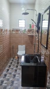 a bathroom with a black sink and a toilet at SriStar in Kluang