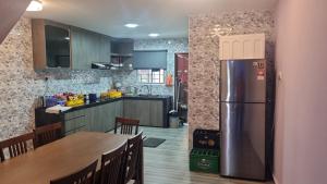 a kitchen with a stainless steel refrigerator and a table at SriStar in Kluang