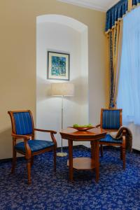 a room with two chairs and a table and a table and chairs at Hotel Ontario in Karlovy Vary