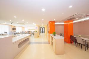 an office with orange and white walls and tables and chairs at Ibis Shanghai Xujiahui in Shanghai