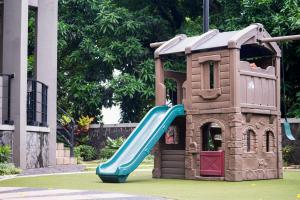 a small play house with a blue slide at Trivana Pool View 3BR Senayan in Jakarta