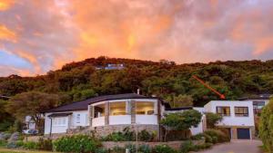 a house with a rainbow in the sky at Blue Bay Studio Apartment in Wilderness