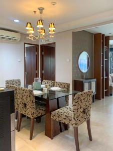 a dining room with a glass table and chairs at Trivana Pool View 3BR Senayan in Jakarta
