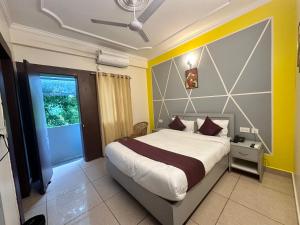 a bedroom with a large bed and a window at Hotel Clover Inn malsi in Dehradun