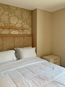 a bedroom with a large bed with white sheets at Trivana Pool View 3BR Senayan in Jakarta +103 photos
