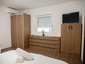 a bedroom with a bed with a tv on the wall at Megdan prenočište in Požarevac