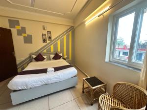 a bedroom with a bed and two windows at Hotel Clover Inn malsi in Dehradun +7 photos