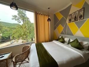 a bedroom with a large bed and a large window at Hotel Clover Inn malsi in Dehradun
