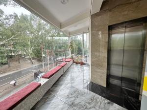 a lobby with red benches and a large window at Hotel Clover Inn malsi in Dehradun