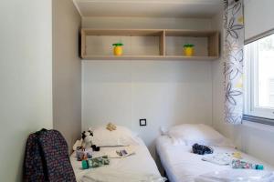 two beds in a room with white walls at ZEcamping 4 étoiles familial espace aquatique locatif TV LV clim in Sérignan